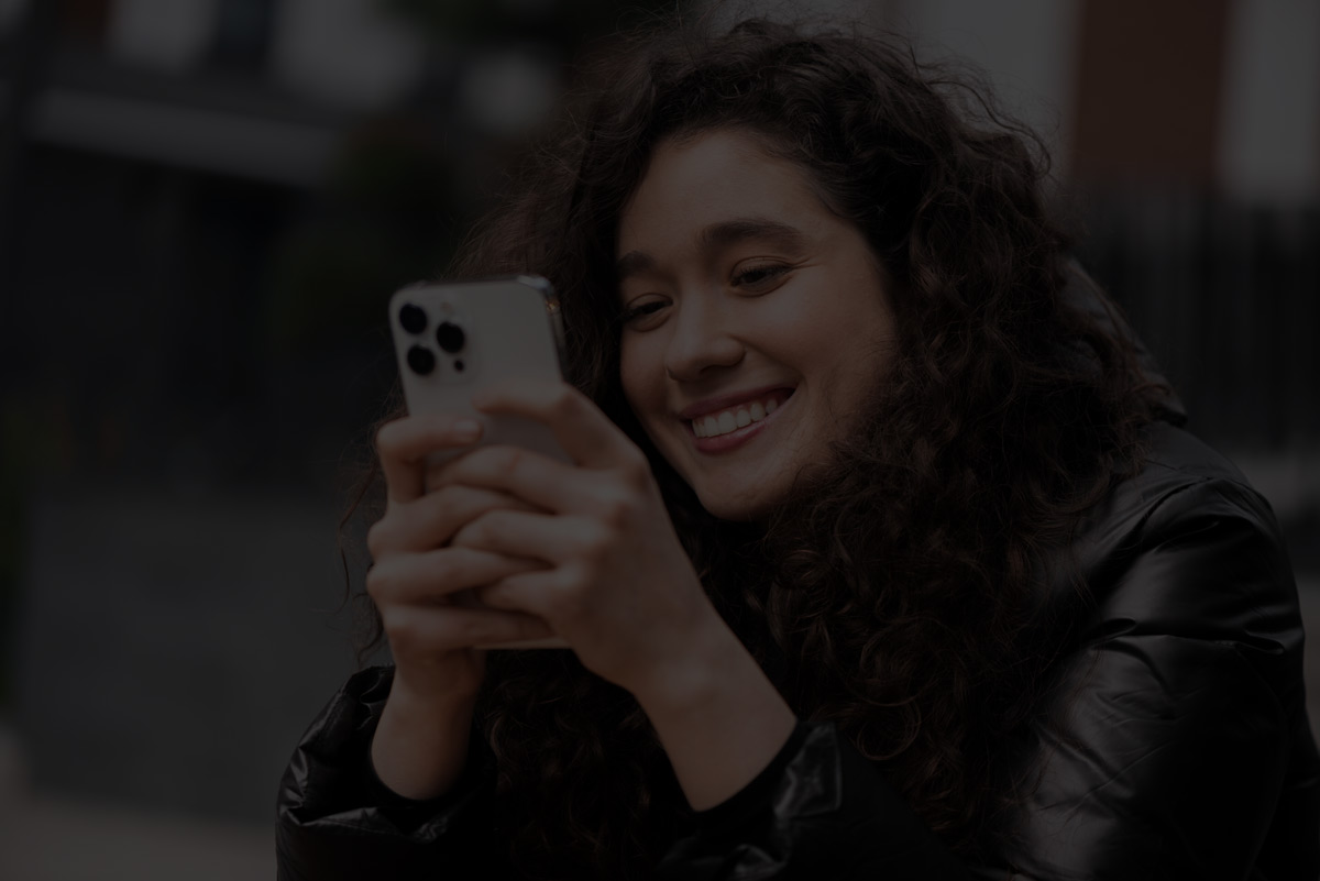 Mulher sorrindo ao usar o celular